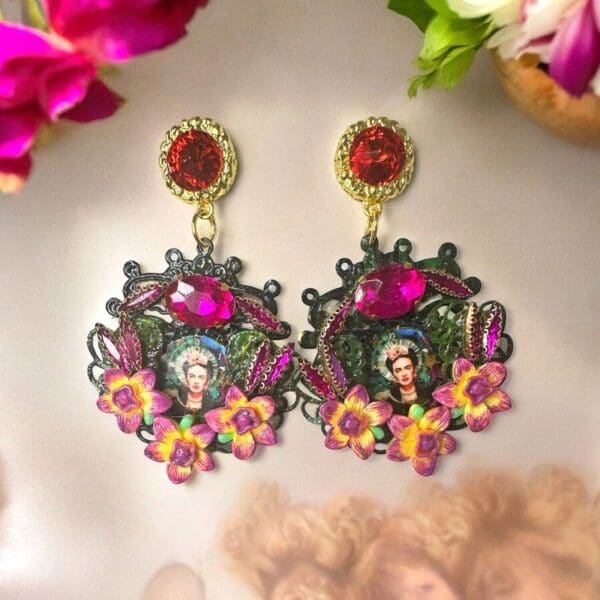 A pair of earrings with flowers and a woman 's face.