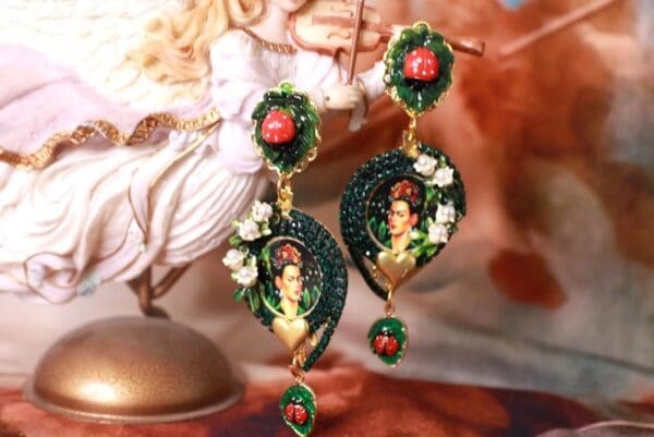 A pair of earrings with flowers and a woman 's face.