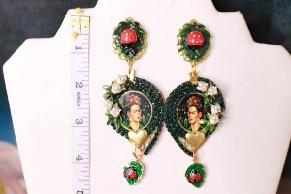 A pair of earrings with flowers and a woman 's face.