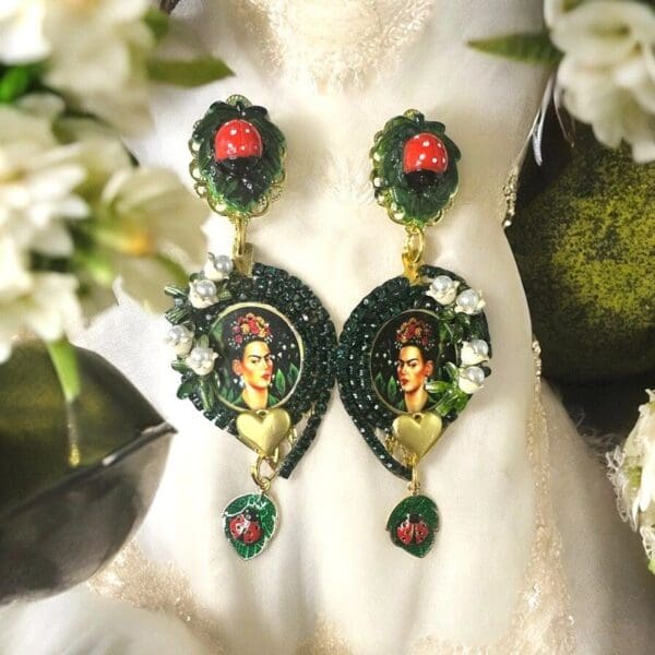 A pair of earrings with flowers and leaves.