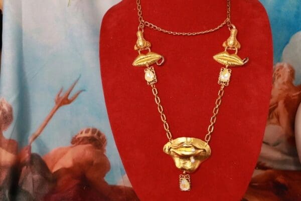A red necklace with a gold chain and a face on it