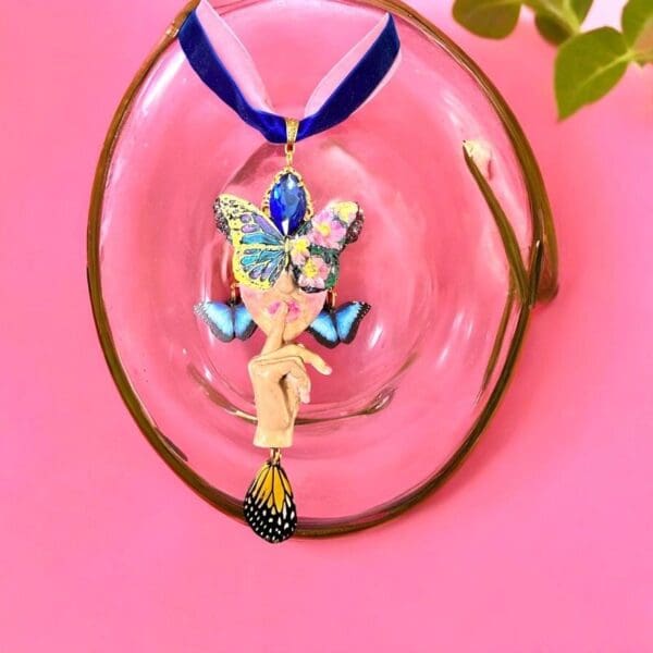 A glass bowl with a necklace hanging on it