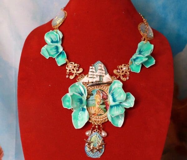 A necklace with blue flowers and a boat on it.