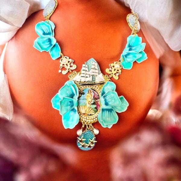 A woman wearing a necklace with turquoise flowers.