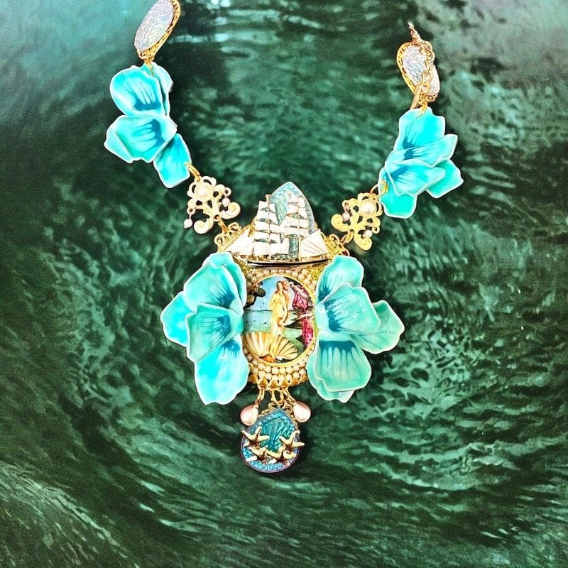 A necklace with turquoise beads and a face on it.