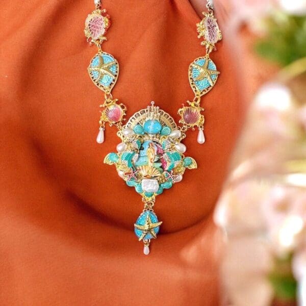A woman wearing a necklace with an image of jesus.