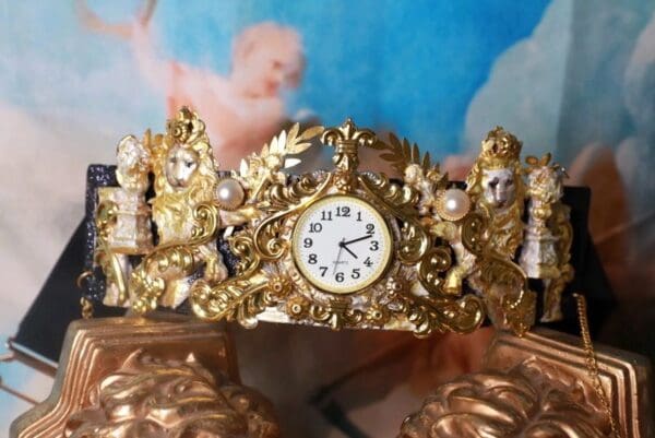 A gold clock sitting on top of a table.