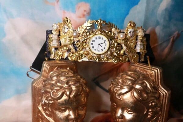 A gold statue with two golden statues and a clock.