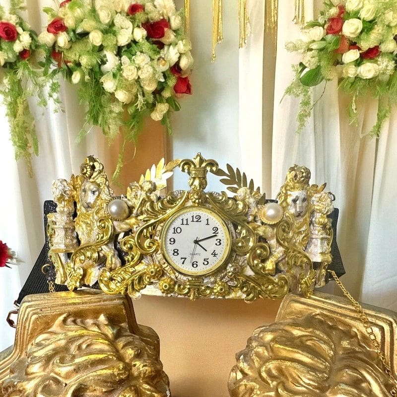 A gold clock sitting on top of a table.