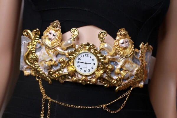 A gold and white clock with chain around it.