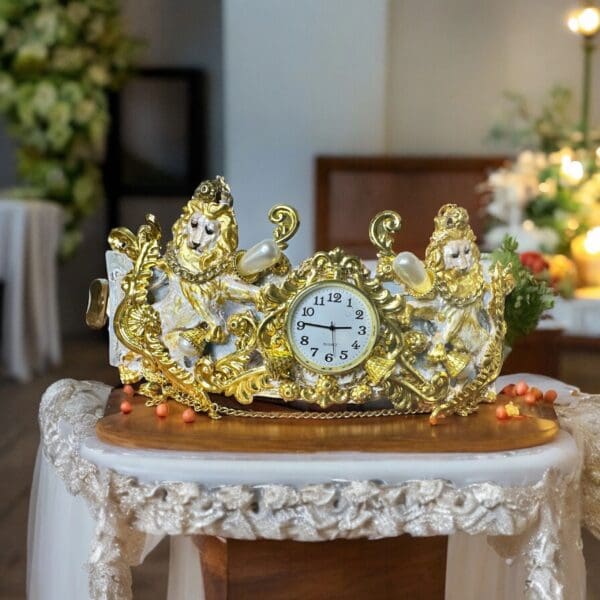 A gold clock sitting on top of a table.