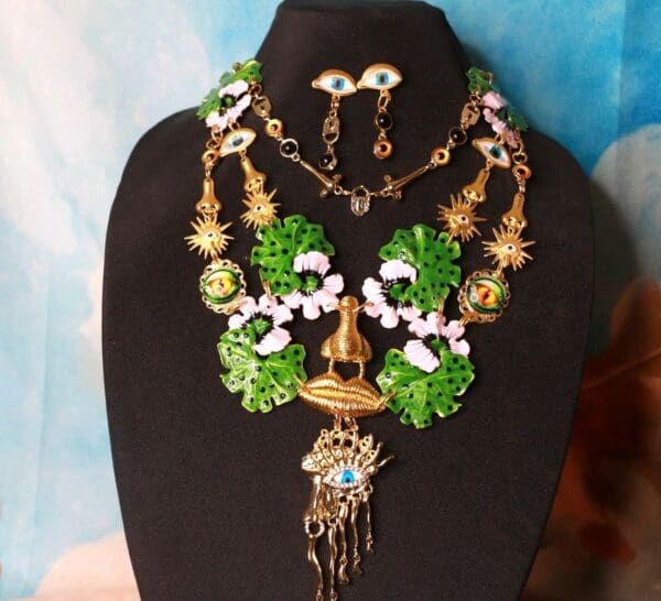 A necklace and earrings set with green leaves.
