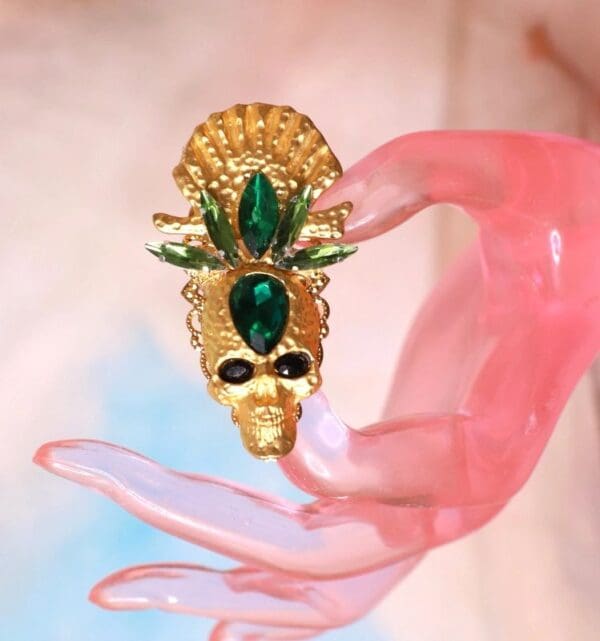 A person holding onto a gold and green mask