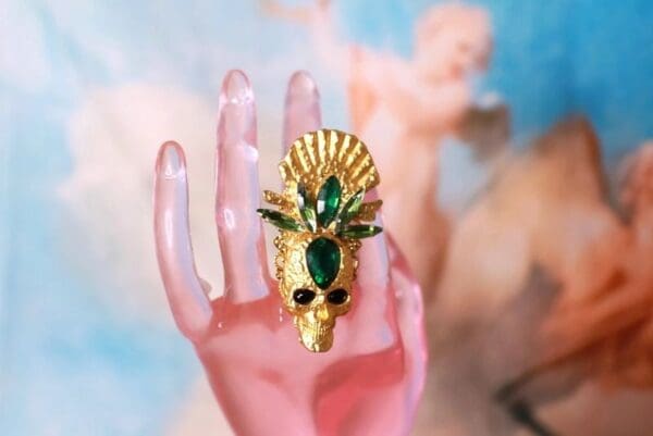 A hand with a gold mask on it