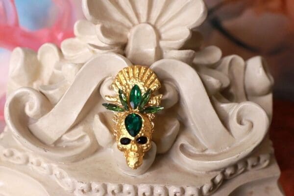 A gold and green skull with a crown on top of it.
