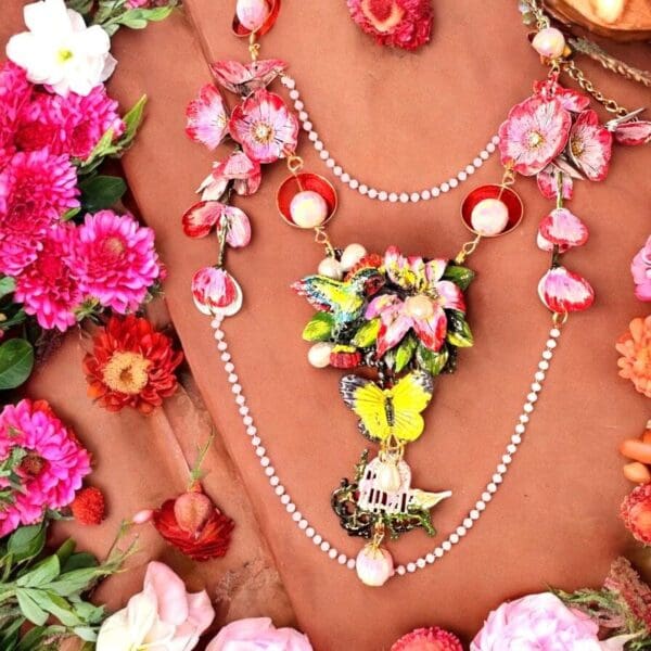 A necklace with flowers and pearls on top of the table.