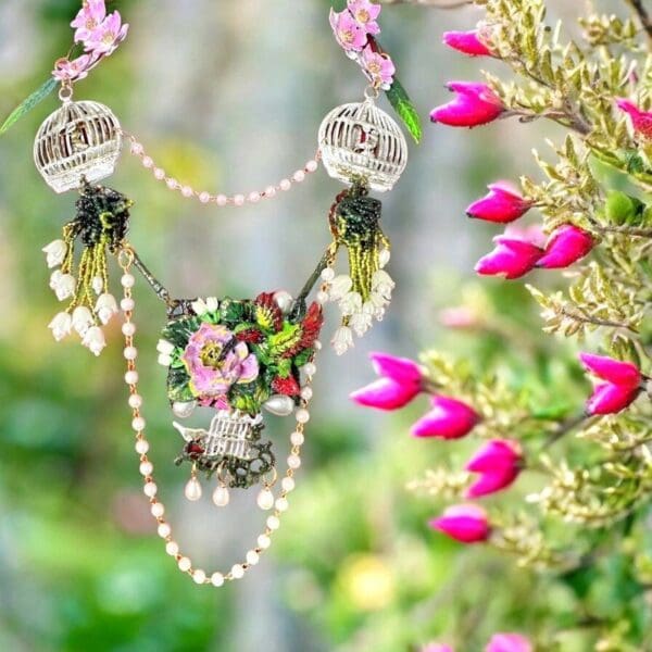 A necklace with flowers and pearls hanging from it.