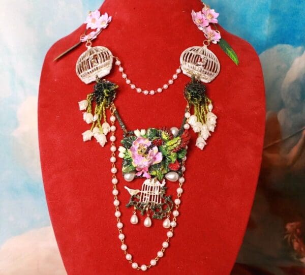 A red display stand with a necklace and earrings.