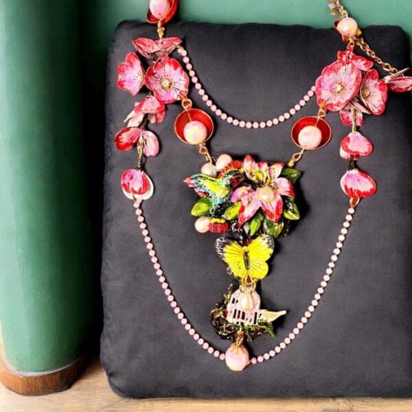 A black bag with a necklace and flowers on it