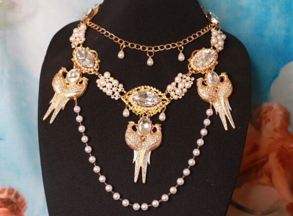 A necklace with pearls and gold chains on it.
