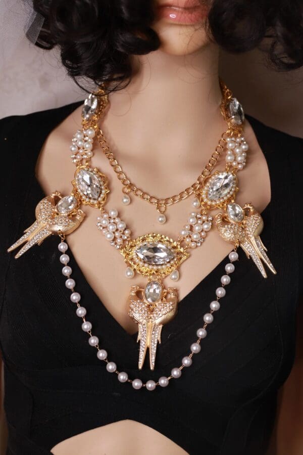 A woman wearing a necklace with pearls and jewels.