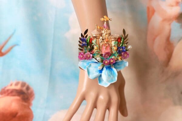 A hand with a blue bow and some flowers