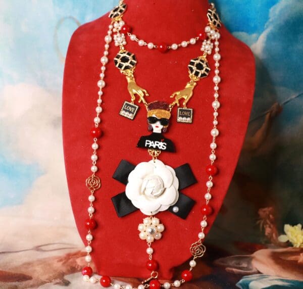 A red necklace with white flowers and pearls.