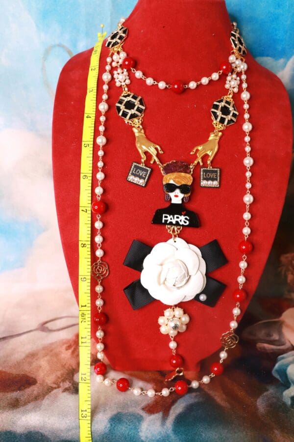 A red necklace with several different charms on it.