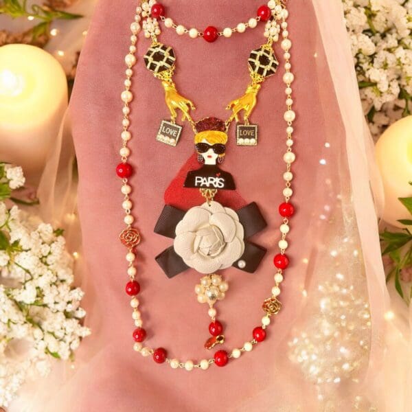 A necklace with a red and white bead is shown.