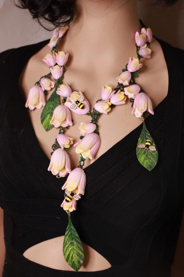 A woman wearing a necklace of pink flowers.