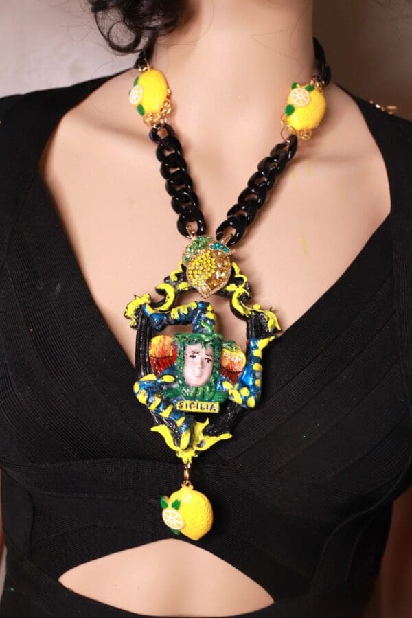 A woman wearing a necklace with yellow beads and a picture of a person.
