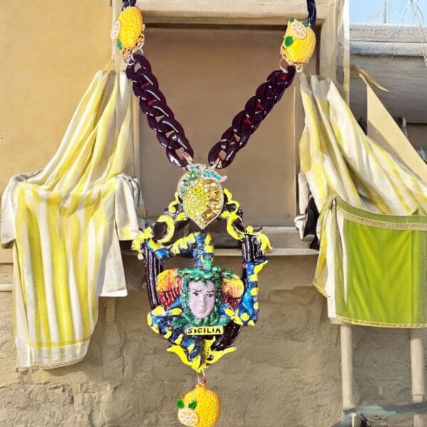 A yellow and green hanging decoration with a face on it.