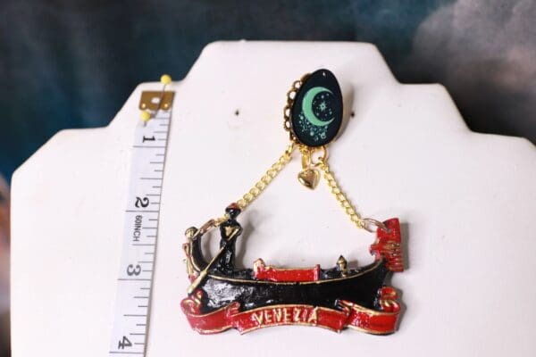 A small pin with a chain and a ruler