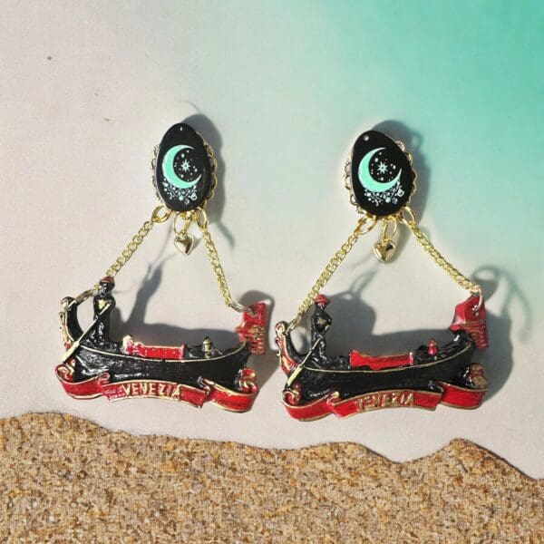 A pair of earrings that are hanging on the sand.