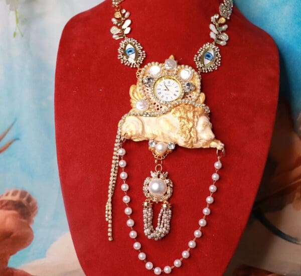 A necklace with pearls and a lion on it