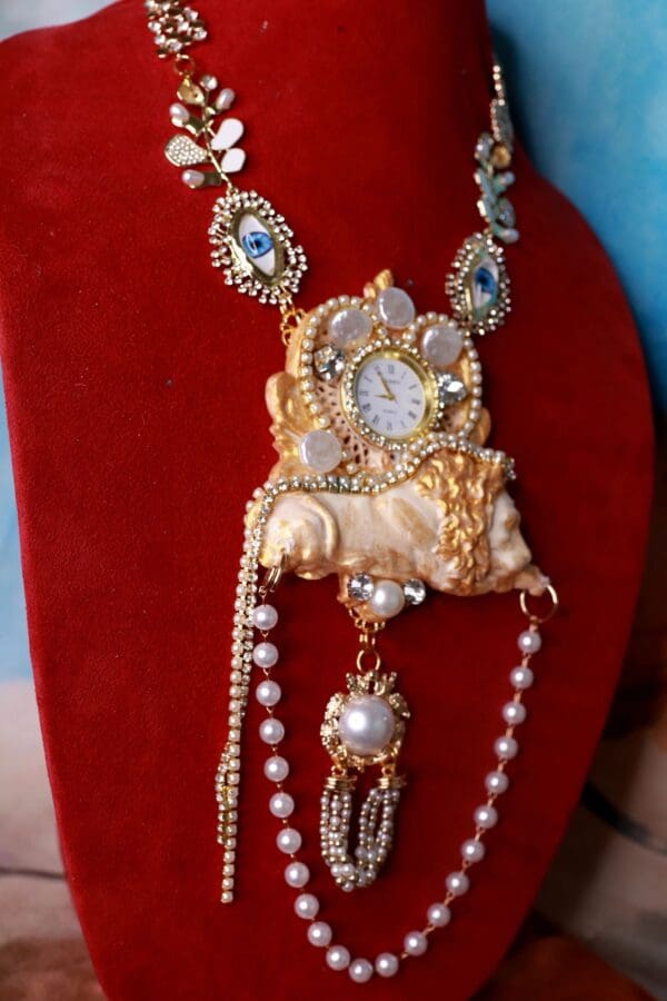 A necklace with pearls and a clock on it