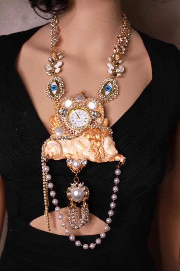 A woman wearing a necklace with pearls and a watch.