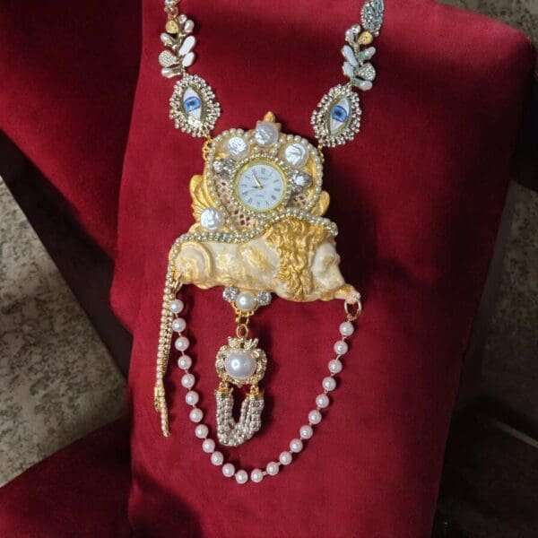 A red chair with a necklace and some gold