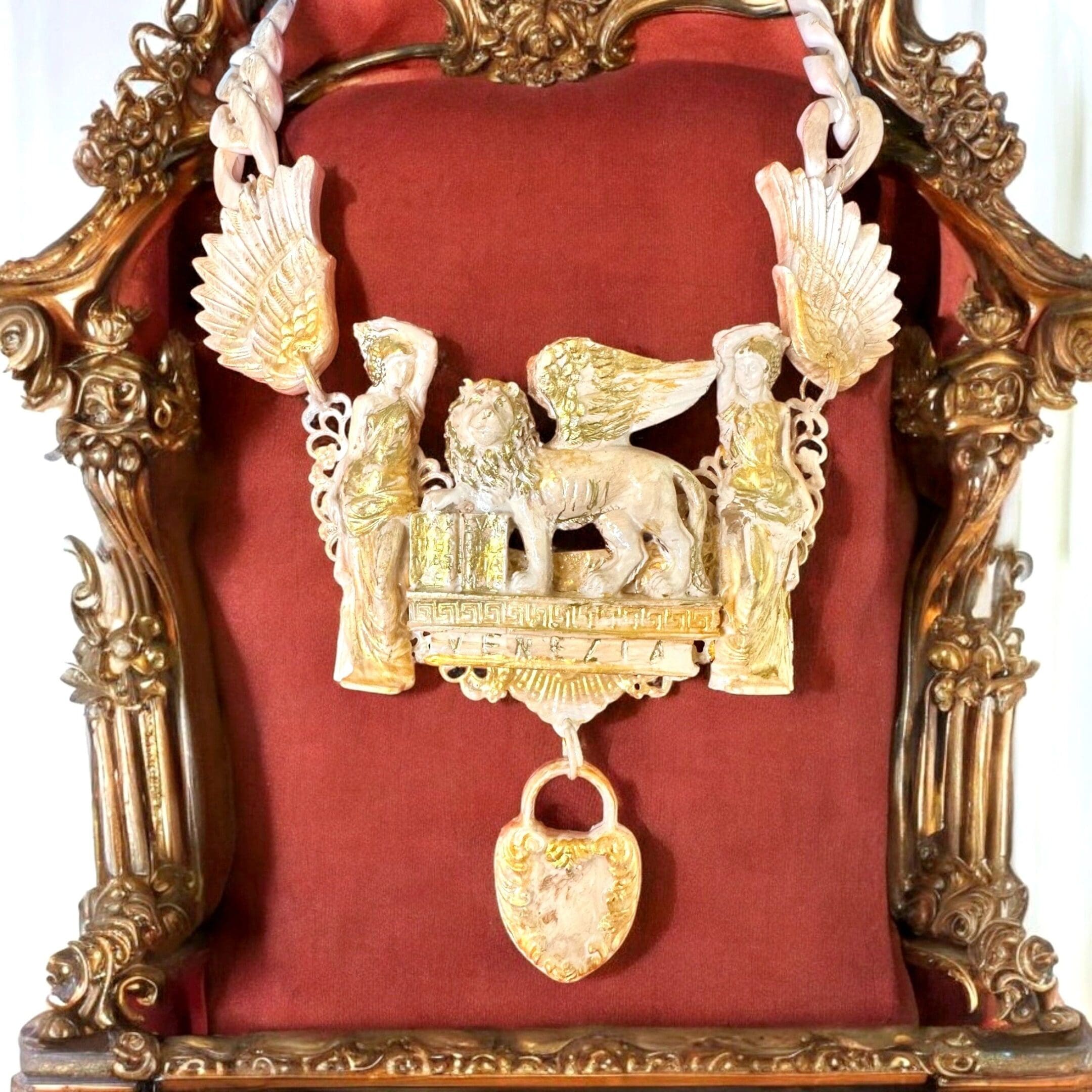 A red velvet chair with gold frame and ornate carvings.