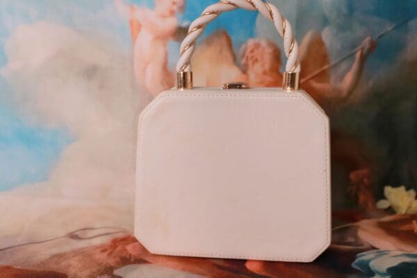 A white purse sitting on top of a table.