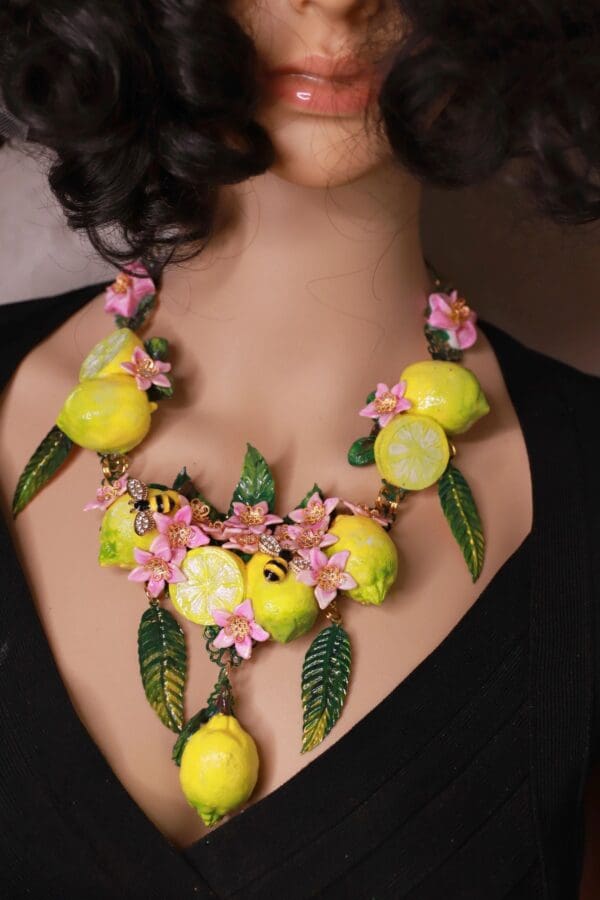 A woman wearing a necklace made of lemons and flowers.