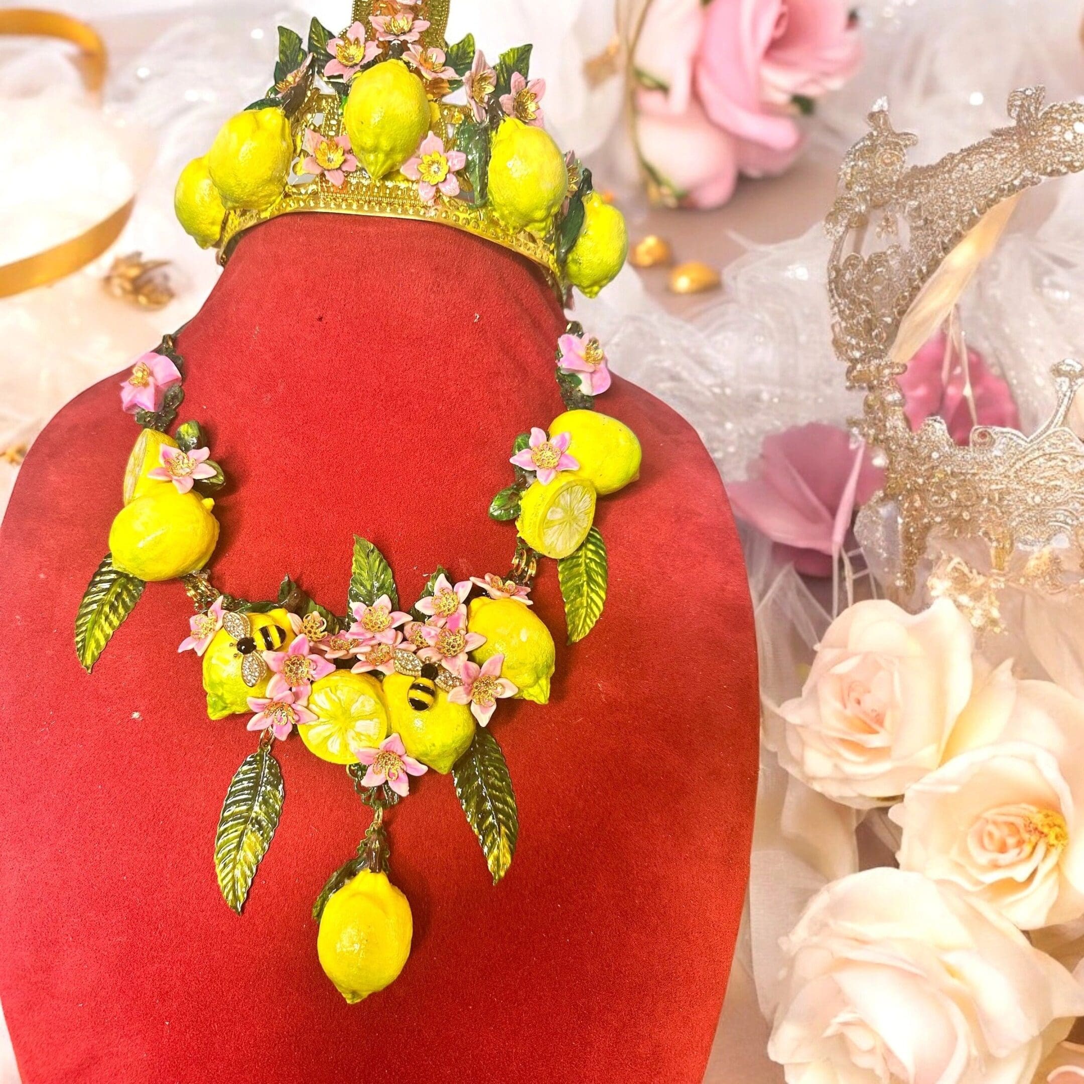 A red vase with yellow and pink flowers on top of it.