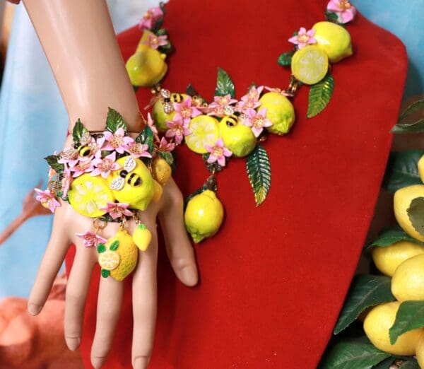 A woman wearing a bracelet and hand with lemons on it.
