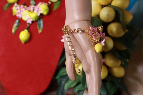 A hand with a chain and flowers on it