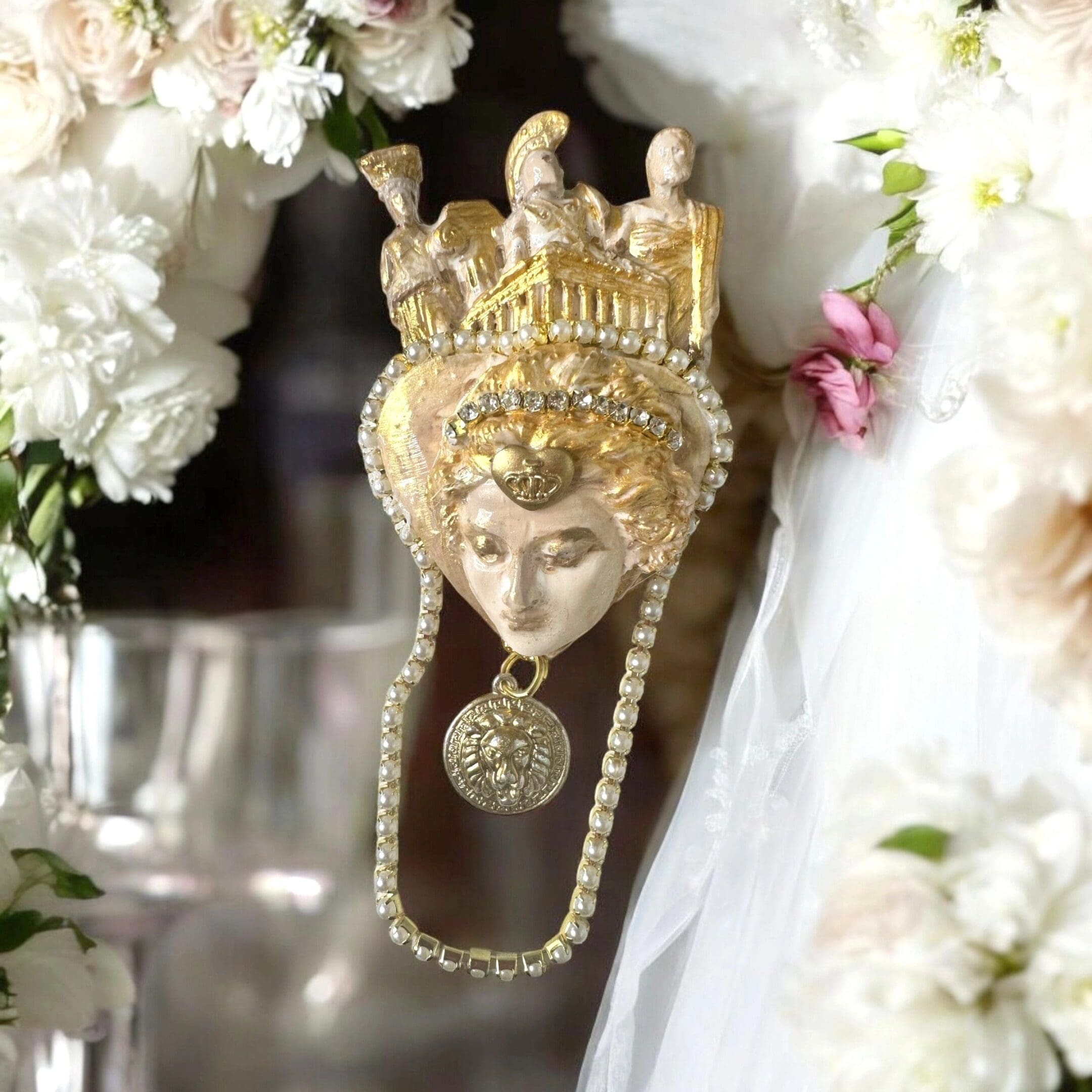 A mask with flowers around it and a coin