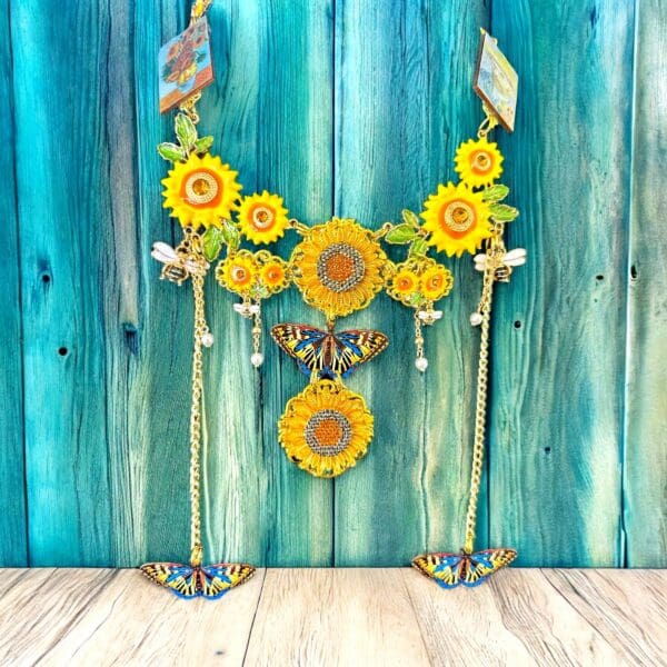 A blue wall with two yellow sunflowers hanging from it.