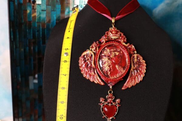 A red necklace with a yellow ribbon hanging from it.