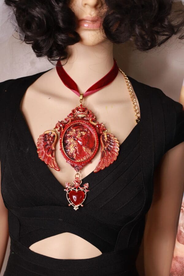 A woman wearing a red necklace with a picture of a person.