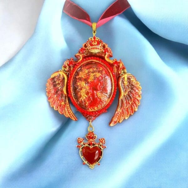 A red and gold necklace with wings on it