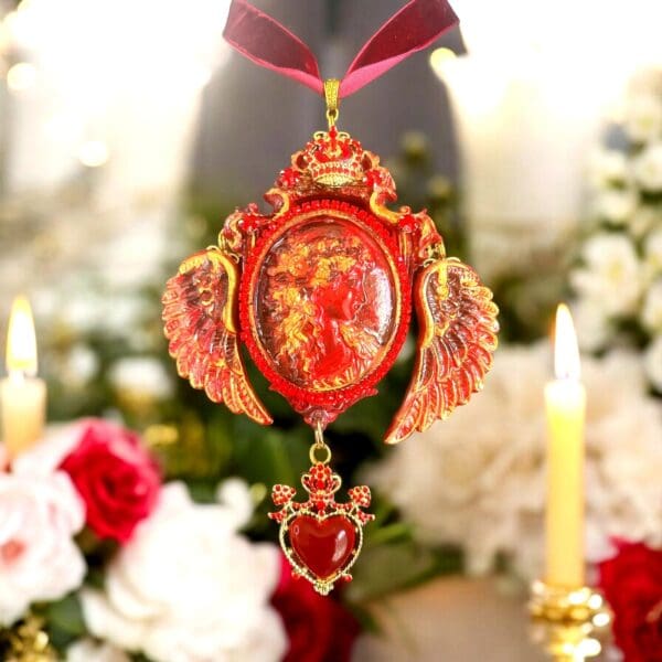 A red and gold ornament hanging from a ribbon.
